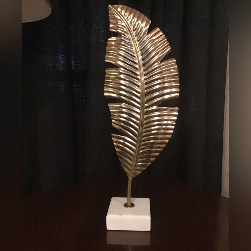 Large gold metal leaf on marble stand